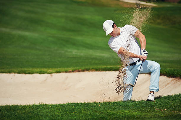 Golfer đang gõ cát khỏi giày khi rời bunker - hành động nhỏ mang ý nghĩa lớn